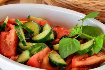 Healthy vegetable salad with cucumber,tomatoes on a white porcelain bowl