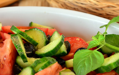 Healthy vegetable salad with cucumber,tomatoes on a white porcelain bowl