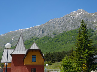 Fototapeta na wymiar Italian landscape in summer - snowy mountain and house