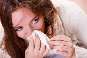 Sick woman girl with fever sneezing in tissue