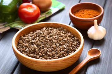 Raw textured vegetable or soy protein, called also soy meat in wooden bowl, photographed with...