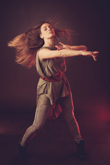 Young brunette caucasian woman dancing and her hair flowing through the air