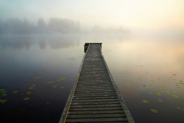 Wooden boat dock on the mysty lake. Finland