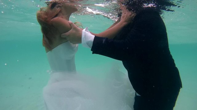 UNDERWATER: Bride and groom kissing under water, Indian Ocean, Maldives
