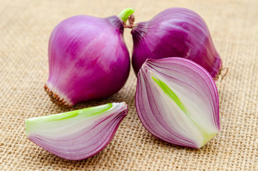 Red onion with green leaves.