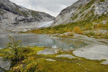 Glacier and glacial lake in the autumn landscape of Norway