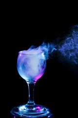 Blue and purple smoke in the glass. Halloween.
