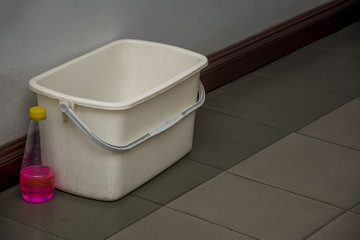 Bucket of water and Floor Cleaner, Ready to mops, in dim light.