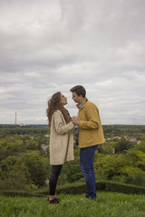 Young intimate couple standing on high viewpoint. Romantic lands