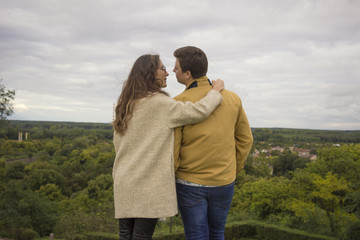 Young intimate couple standing on high viewpoint. Romantic lands