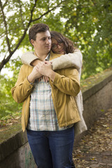 Fototapeta premium Young couple, boyfrind hugging girlfriend. Girlfriend looking to