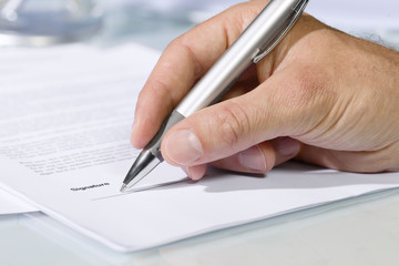 Close-up shot of hand signing a document