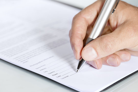 Close-up shot of hand signing a document