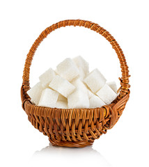 sugar cubes in a brown wicker basket close-up isolated on a white background