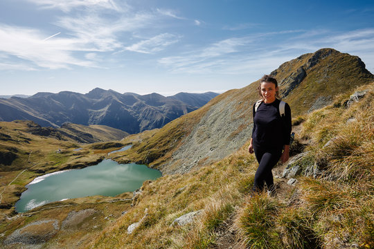 Backpacker lady hiking by the lake in the mountains
