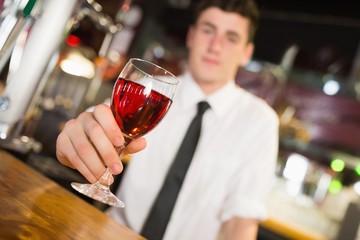 Male barkeepe serving alcohol