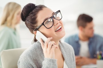 Happy woman wearing eyeglasses talking on smartphone 