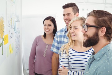 Fototapeta premium Smiling business people looking at sticky notes