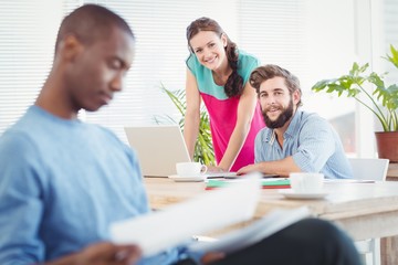 Fototapeta premium Portrait of business people at desk with person 