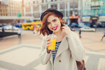 young stylish pretty woman with juice posing in the city streets. vacation europe