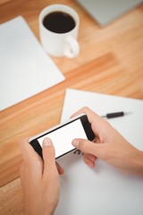 Man using smartphone at desk in office