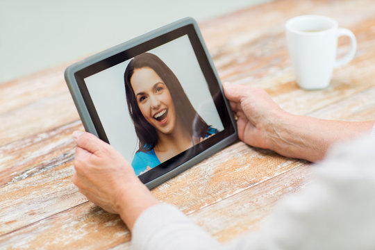 senior woman with photo on tablet pc at home