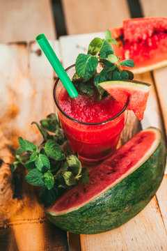 watermelon smoothie and fresh on a light wood background. selective focus to mint
