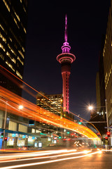 Motion traffic light trail of vehicles in Auckland CBD in the foreground with the Sky Tower in the...