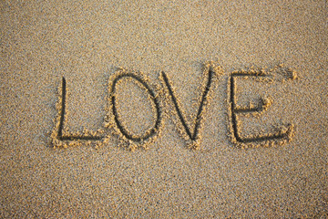 close up of word love written in sand