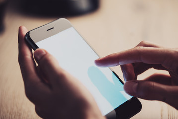 Blank screen of smart phone using in female hand.