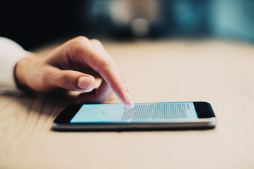 Smartphone with a text. Female hand touching screen