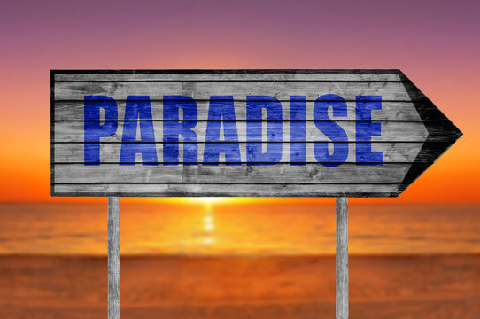 Paradise wooden sign with on a beach background