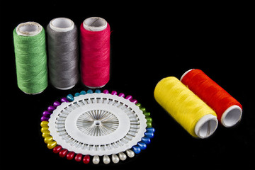 thread and pin on black isolated background