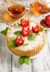 Celebratory cake with strawberry flowers and tea