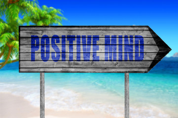 Positive mind wooden sign with on a beach background