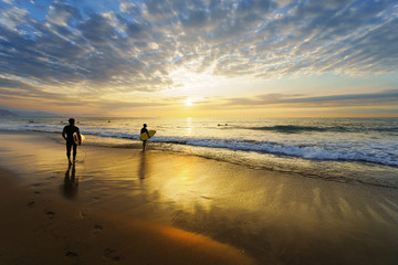 Fototapeta na wymiar surfers entering water on Sopelana beach