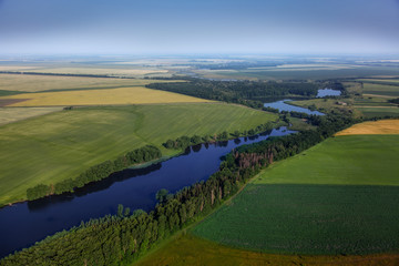 Fototapeta na wymiar aerial view above the green fields and river