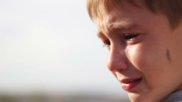 dirty orphan boy close up crying