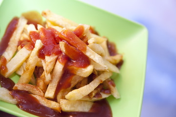 Potatoes fries in green plate on kitchen table