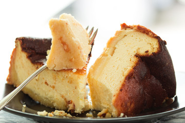 Käsekuchenstücke auf Kuchengabel vor hellem Hintergrund