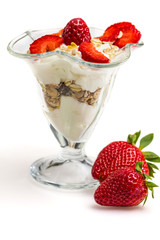 Glass of Muesli with strawberries and yogurt isolated on white