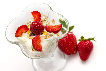 Glass of Muesli with strawberries and yogurt isolated on white