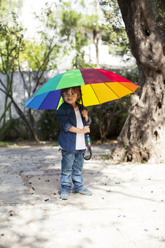 Young boy with umbrella in garden