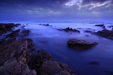 Fototapeta na wymiar Styx / This is the coast of the Cape Peninsula, South Africa, at sunset. These rugged rocks remind the river Styx of the ancient Greek mythology.