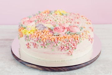 Pastel pink cake decorated with cream flowers