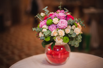Beautiful bouquet of bright flowers in glass vase, on table