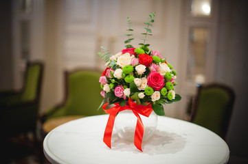 Beautiful bouquet of bright flowers in glass vase, on table