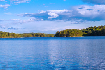 Lake summer view with reflection of clouds on water, Finland