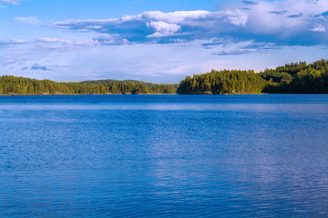 Lake summer view with reflection of clouds on water, Finland