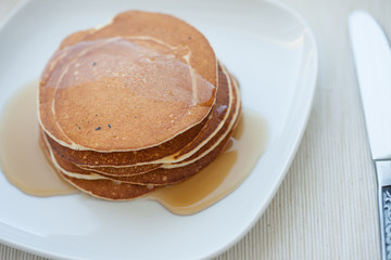 Stack of pancakes with  maple syrup, top view